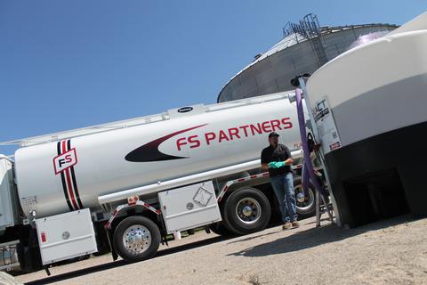 driver standing beside tanker filling an EXACT Tank system